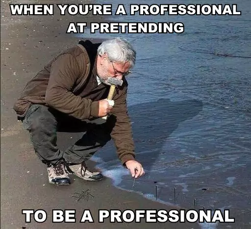 A man hammers nails into the sand